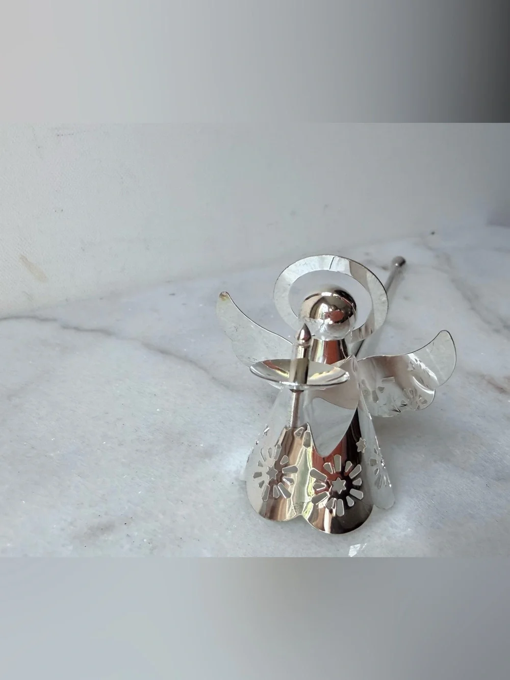 silver-tone angel candle snuffer features intricate, cutout wing and robe